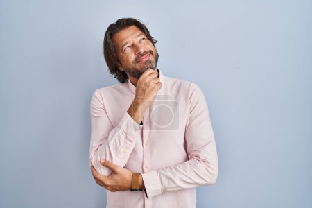Photo for Handsome middle age man wearing elegant shirt background with hand on chin thinking about question, pensive expression. smiling and thoughtful face. doubt concept. - Royalty Free Image