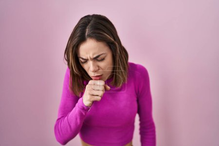 Foto de Mujer hispana de pie sobre fondo rosa sintiéndose mal y tosiendo como síntoma de resfriado o bronquitis. concepto de atención sanitaria. - Imagen libre de derechos