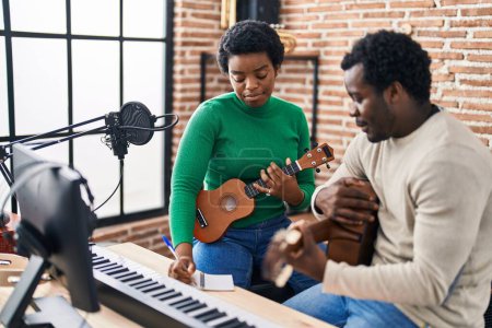 Téléchargez les photos : African american man and woman music group compising song at music studio - en image libre de droit