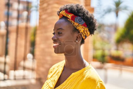 Téléchargez les photos : Jeune femme afro-américaine souriante confiante debout dans la rue - en image libre de droit