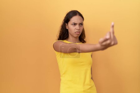 Téléchargez les photos : Jeune femme afro-américaine faisant un mauvais geste avec les doigts sur fond jaune isolé - en image libre de droit