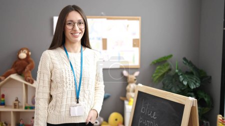 Photo for Young beautiful hispanic woman preschool teacher smiling confident standing at kindergarten - Royalty Free Image