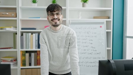 Photo for Young hispanic man standing by white board at university classroom - Royalty Free Image