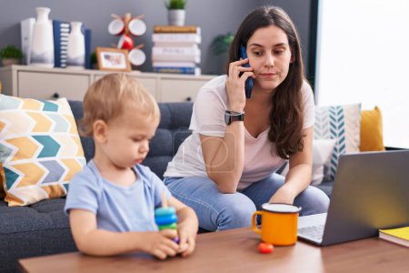 Foto de Madre e hijo estresados hablando en el teléfono inteligente jugando en casa - Imagen libre de derechos
