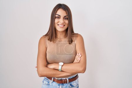 Téléchargez les photos : Young hispanic woman standing over white background happy face smiling with crossed arms looking at the camera. positive person. - en image libre de droit