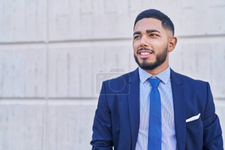 Téléchargez les photos : Jeune homme d'affaires latino-américain souriant confiant debout sur fond blanc isolé - en image libre de droit