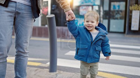 Téléchargez les photos : Caucasien bambin souriant joyeux tenant la main avec papa à la rue - en image libre de droit