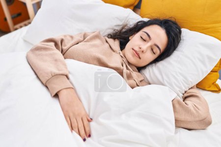 Foto de Mujer hispana joven durmiendo en la cama en el dormitorio - Imagen libre de derechos