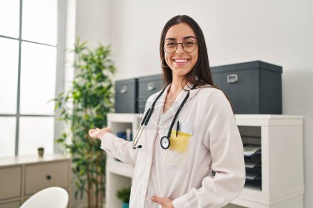 Photo for Young beautiful hispanic woman doctor smiling confident doing coming gesture with hand at clinic - Royalty Free Image