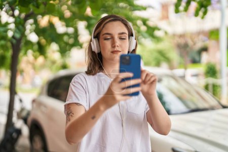 Téléchargez les photos : Young woman smiling confident listening to music at street - en image libre de droit