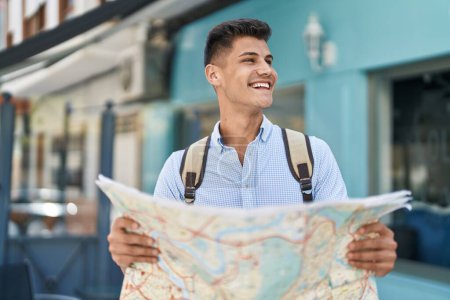 Téléchargez les photos : Young hispanic man student smiling confident holding city map at street - en image libre de droit