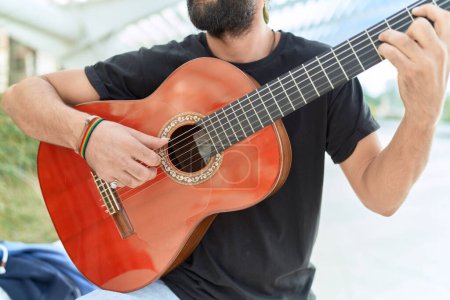 Photo for Young hispanic man musician playing classical guitar at park - Royalty Free Image