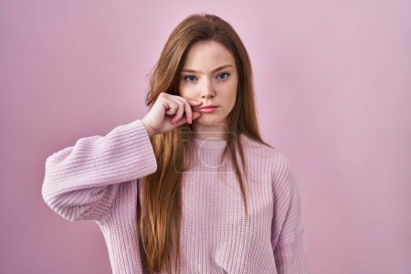 Photo for Young caucasian woman standing over pink background mouth and lips shut as zip with fingers. secret and silent, taboo talking - Royalty Free Image