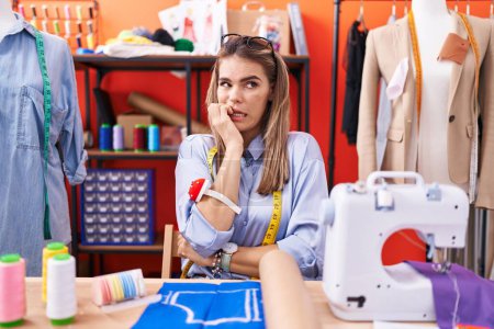 Photo for Hispanic young woman dressmaker designer at atelier room looking stressed and nervous with hands on mouth biting nails. anxiety problem. - Royalty Free Image