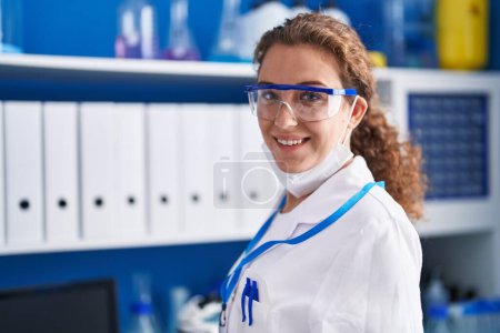 Foto de Joven hermosa mujer hispana científica con máscara médica en el laboratorio - Imagen libre de derechos
