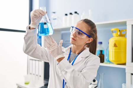 Photo for Young blonde woman wearing scientist uniform holding test tube at laboratory - Royalty Free Image