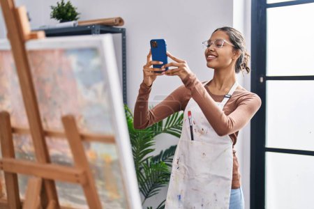 Téléchargez les photos : Jeune artiste afro-américaine souriante confiante faire des photos au studio d'art - en image libre de droit