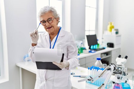 Photo for Senior grey-haired woman wearing scientist uniform with doubt expression at laboratory - Royalty Free Image