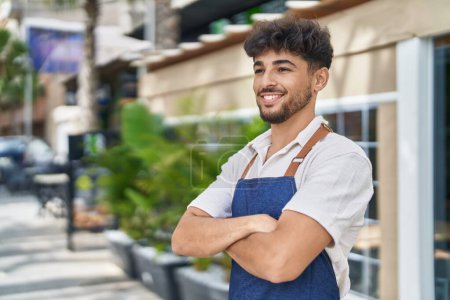 Téléchargez les photos : Young arab man waiter standing with arms crossed gesture at restaurant - en image libre de droit