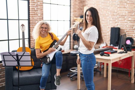 Téléchargez les photos : Deux femmes musiciens chantant une chanson jouant de la guitare électrique au studio de musique - en image libre de droit