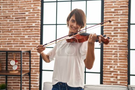 Photo for Young beautiful hispanic woman musician smiling confident playing violin at home - Royalty Free Image