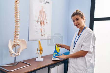 Photo for Young blonde woman podiatrist holding insole at clinic - Royalty Free Image