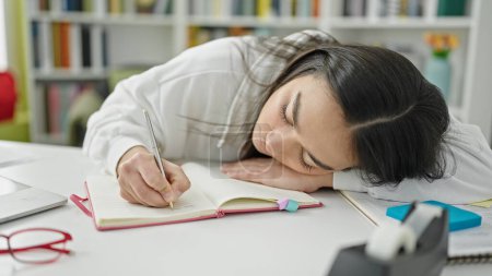 Photo for Young beautiful hispanic woman student writing notes tired at university classroom - Royalty Free Image