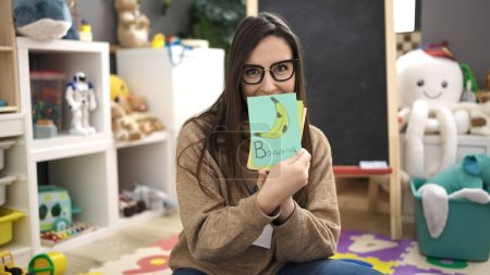 Foto de Hermosa mujer hispana maestra de preescolar que enseña lección de vocabulario en el jardín de infantes - Imagen libre de derechos