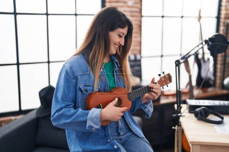 Téléchargez les photos : Jeune musicienne hispanique jouant ukulélé au studio de musique - en image libre de droit