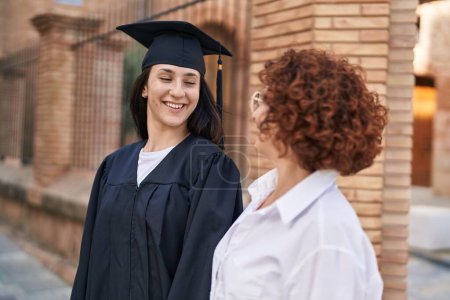 Photo for Two women mother and daughter celebrating graduation at campus university - Royalty Free Image
