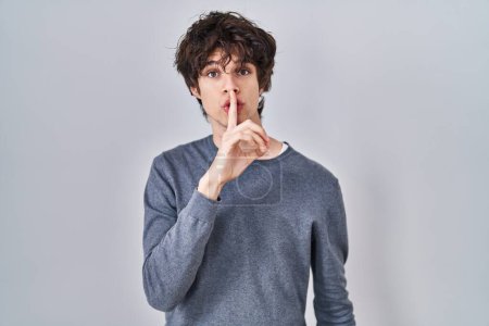 Photo for Young man standing over isolated background asking to be quiet with finger on lips. silence and secret concept. - Royalty Free Image