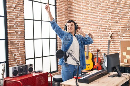 Téléchargez les photos : Jeune homme artiste non binaire écoutant de la musique danser au studio de musique - en image libre de droit