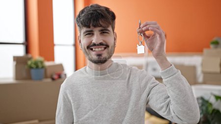 Photo for Young hispanic man smiling confident holding new house keys at new home - Royalty Free Image