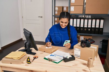 Téléchargez les photos : Jeune femme hispanique e-commerce travailleur d'affaires en utilisant smartphone au bureau - en image libre de droit