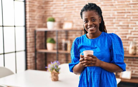 Foto de African american woman business worker smiling confident drinking coffee at home - Imagen libre de derechos