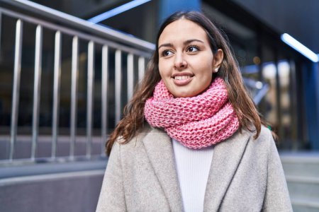 Téléchargez les photos : Young beautiful hispanic woman wearing scarf looking to the side at street - en image libre de droit