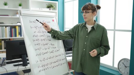 Téléchargez les photos : Young caucasian woman teaching maths on magnetic board at library university - en image libre de droit