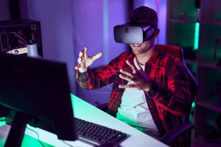 Téléchargez les photos : Young caucasian man streamer playing video game using virtual reality glasses at gaming room - en image libre de droit