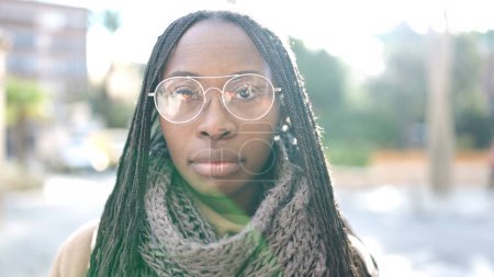 Photo for African woman standing with serious expression wearing glasses at street - Royalty Free Image