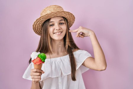 Photo for Teenager girl holding ice cream smiling cheerful showing and pointing with fingers teeth and mouth. dental health concept. - Royalty Free Image