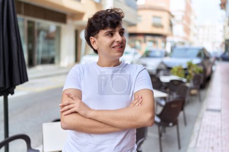 Photo for Non binary man standing with arms crossed gesture at coffee shop terrace - Royalty Free Image