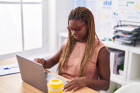 Téléchargez les photos : Femme afro-américaine travailleur d'affaires en utilisant un ordinateur portable travaillant au bureau - en image libre de droit