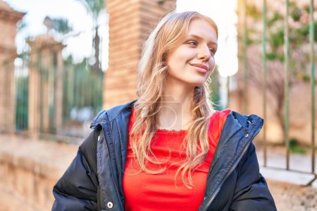 Téléchargez les photos : Young blonde woman smiling confident looking to the side at street - en image libre de droit