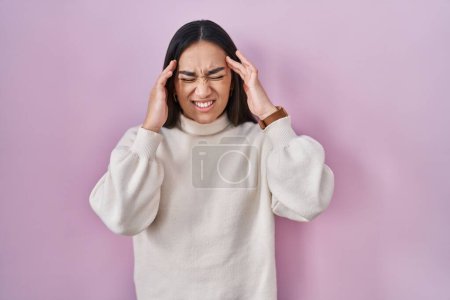 Téléchargez les photos : Jeune femme sud-asiatique debout sur fond rose avec la main sur la tête, maux de tête parce que le stress. migraine souffrant. - en image libre de droit