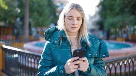 Téléchargez les photos : Young blonde woman using smartphone at park - en image libre de droit