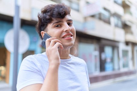 Téléchargez les photos : Non binary man smiling confident talking on smartphone at street - en image libre de droit
