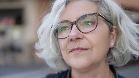 Téléchargez les photos : Middle age woman with grey hair standing with serious expression at street - en image libre de droit