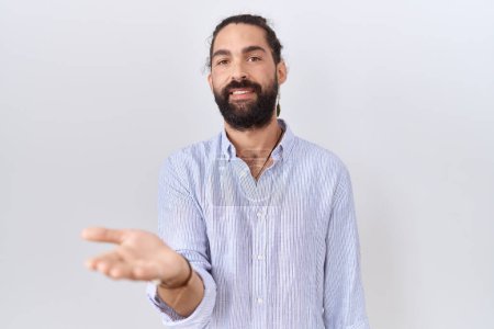 Téléchargez les photos : Homme hispanique avec barbe portant chemise décontractée souriant joyeuse offrant main de paume donnant assistance et acceptation. - en image libre de droit