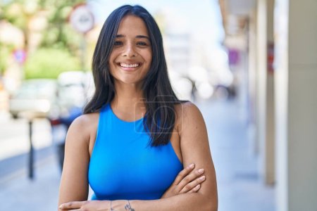 Photo for Young hispanic woman smiling confident standing with arms crossed gesture at street - Royalty Free Image