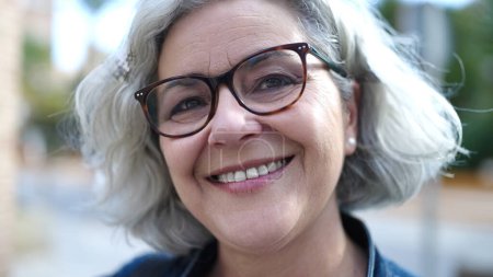Téléchargez les photos : Middle age woman with grey hair smiling confident at street - en image libre de droit